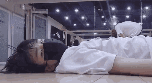 a person is laying on the floor in a dance studio .