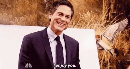 a man in a suit and tie is laughing and saying `` i enjoy you '' .