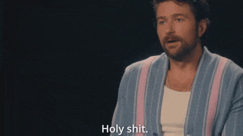 a man in a robe says holy shit in a dark room