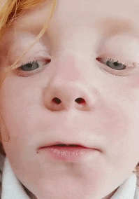 a close up of a child 's face with a serious look on his face