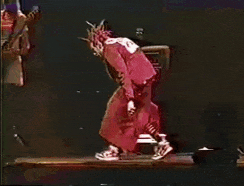 a man in a red outfit with the number 9 on his back is kneeling down on a stage