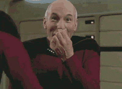 a man in a red sweater is making a funny face and clapping his hands .