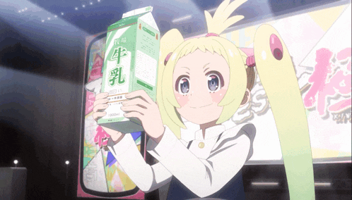 a girl is holding up a carton of milk with chinese writing on it