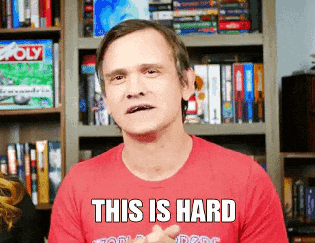 a man wearing a red shirt with the words this is hard on it