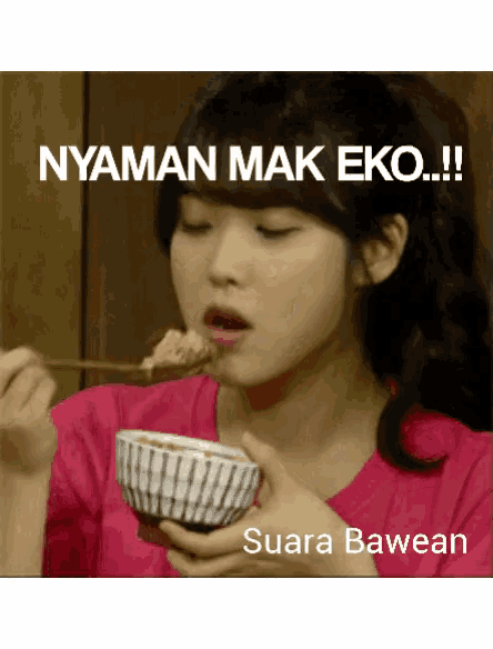 a woman in a pink shirt is eating food from a bowl with a spoon and the caption nyaman mak eko !!