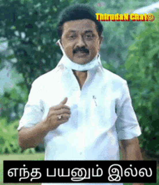 a man wearing a white shirt and a mask is giving a thumbs up sign .