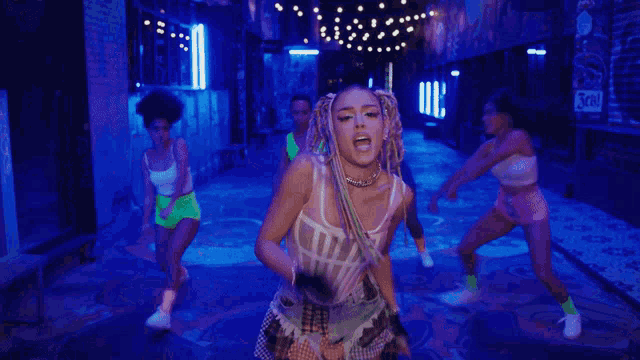 a group of women are dancing in front of a blue light