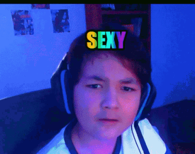 a boy wearing headphones has a sticker on his head that says sexy