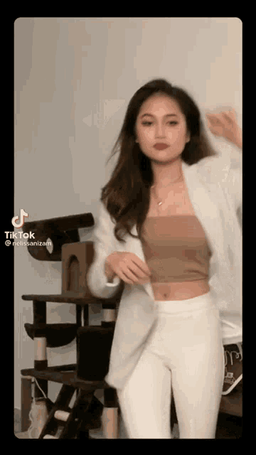 a woman is dancing in front of a cat tree .