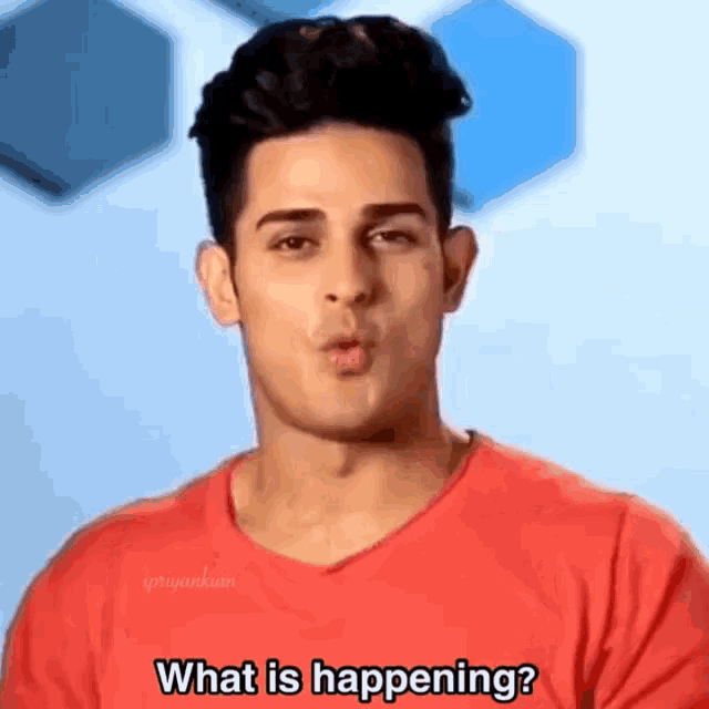 a man in a red shirt is making a face and asking what is happening