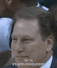 a man in a suit and tie is sitting in a crowd of people .