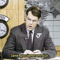 a man in a suit and tie is sitting at a desk and saying jane you ignorant slut