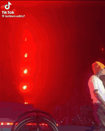 a woman is singing into a microphone while taking off her shirt