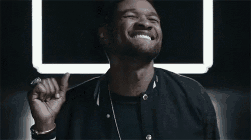 a man in a black jacket is laughing in front of a square light