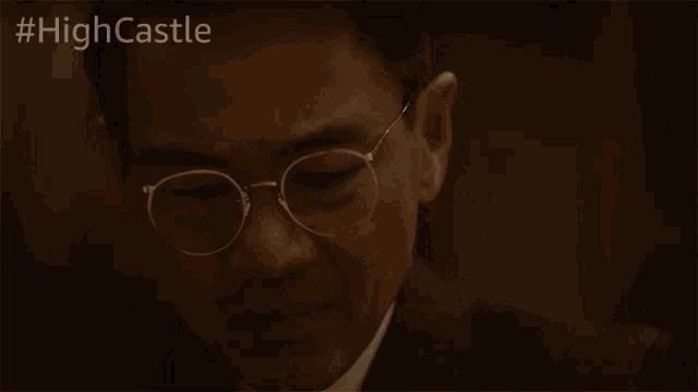 a man in a suit and tie is drinking from a glass with #highcastle written above him