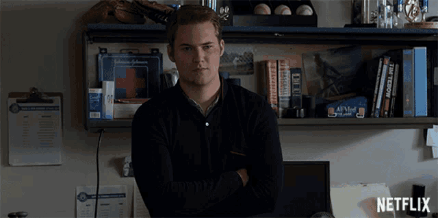 a man stands in front of a shelf with a first aid kit on it and a netflix logo