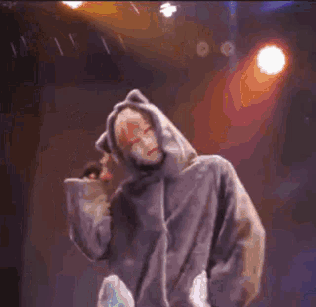 a person wearing a cat ear hooded jacket is walking on a stage