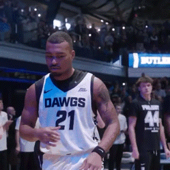a basketball player wearing a dawgs 21 jersey walks on the court