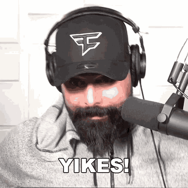 a man with a beard is wearing headphones and a hat that says yikes