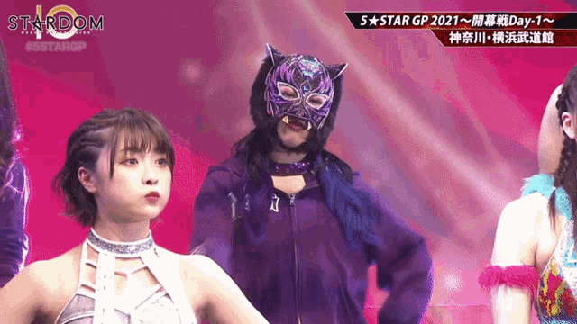 a woman in a mask stands in front of a stardom logo