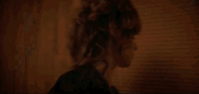 a woman is standing in the doorway of a house looking out the window .
