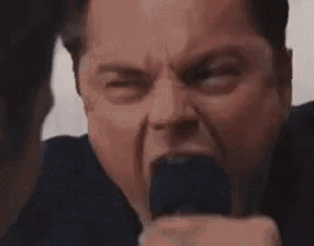 a man in a suit is screaming at another man in a suit .