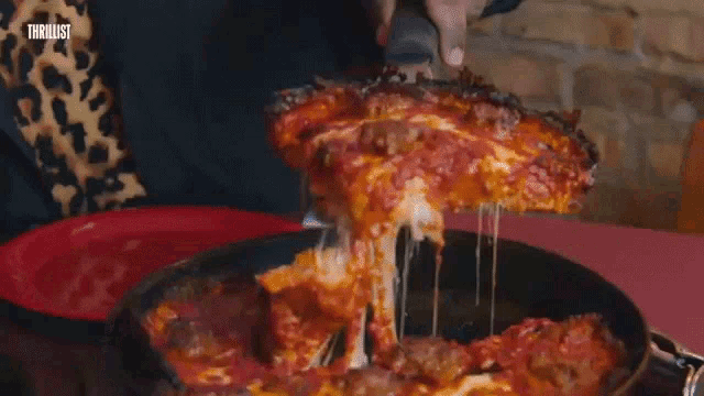 a man with glasses is eating a slice of pizza with a fork .