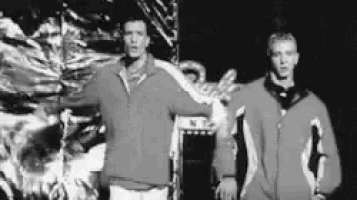 a black and white photo of two men standing next to each other .