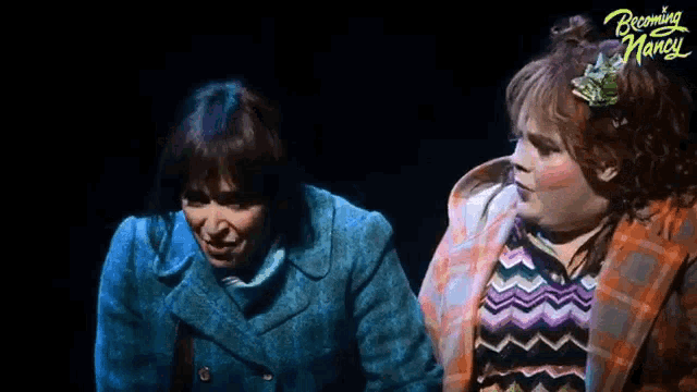 two women are standing next to each other on a stage in a play called becoming marcus .