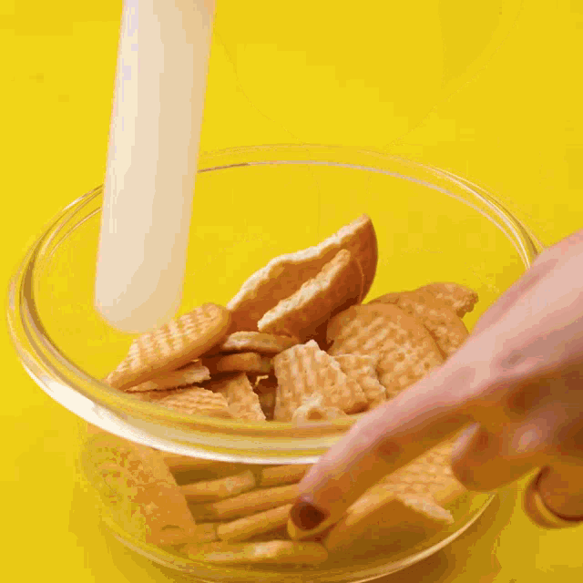 a bowl of crumbs is being poured into a bowl of oatmeal