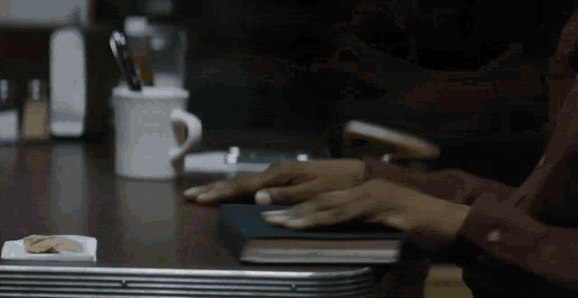 a person sits at a table with a book and a cup of coffee