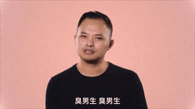 a man in a black shirt is standing in front of a pink background with chinese characters