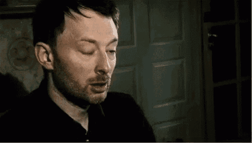 a man with a beard is sitting in front of a door .
