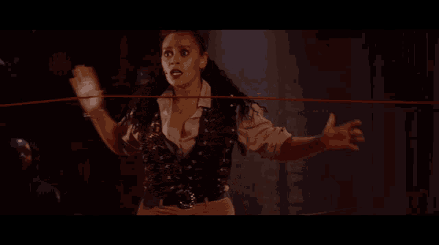 a woman in a vest is holding a red string