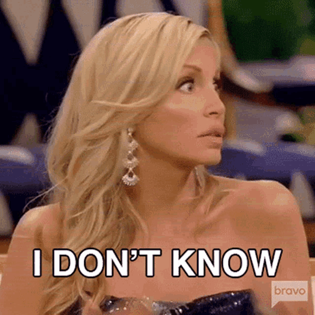 a woman in a strapless dress is sitting at a table and says `` i don t know '' .