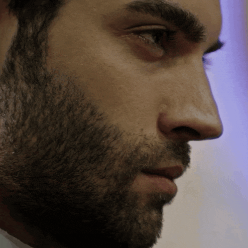 a man with a beard looks at the camera
