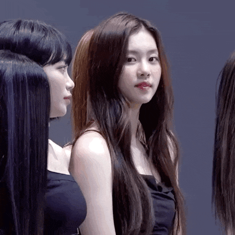 a group of women are standing next to each other and one of them is looking at the camera .