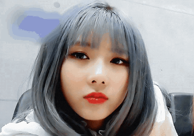 a close up of a woman 's face with grey hair and red lips