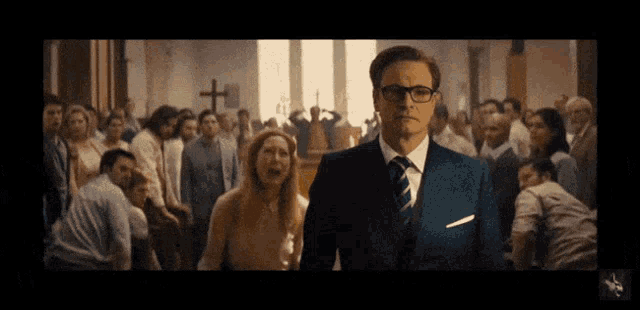 a man in a suit and tie is standing in front of a crowd