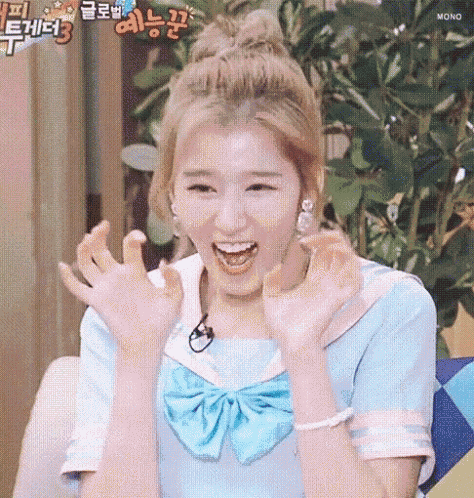 a woman in a blue dress and bow tie is making a funny face with her hands in the air .