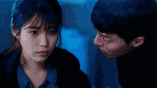 a man and a woman are looking at each other with their eyes closed .
