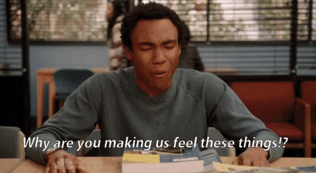 a man sits at a desk with a book and says why are you making us feel these things