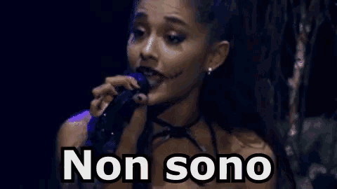 ariana grande is wearing a halloween costume and singing into a microphone with the words non sono written below her .