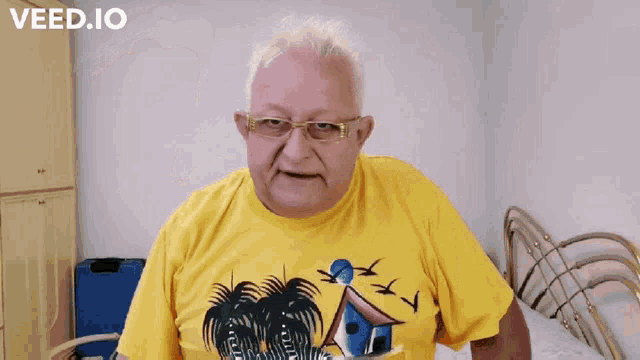 a man wearing glasses and a yellow shirt with the words col cazzo on the bottom