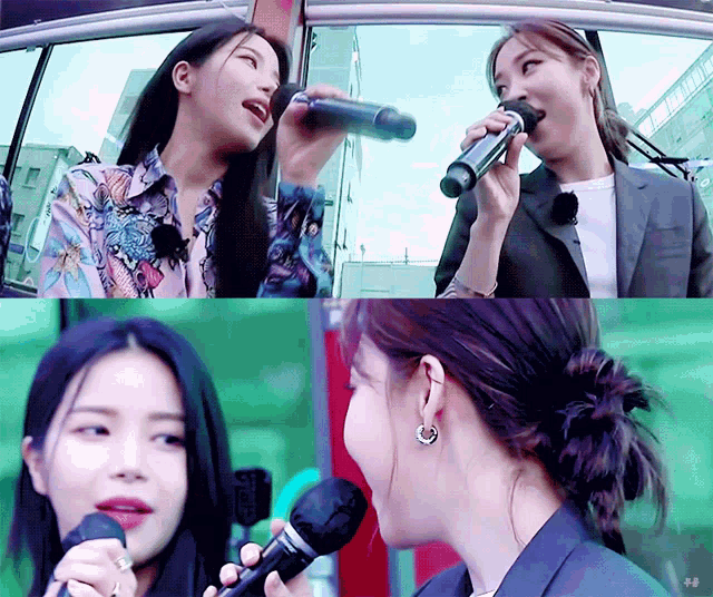 a woman singing into a microphone with another woman behind her