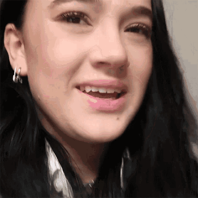 a close up of a woman 's face with hoop earrings on