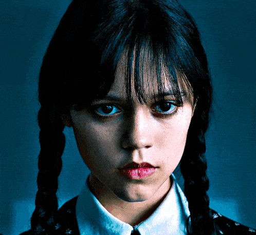 a close up of a woman 's face with braids and a white shirt