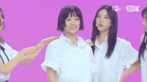 a group of young women are standing in front of a pink background with the word studio k on it