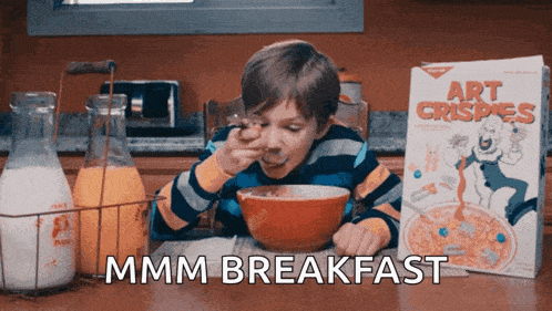 a boy is eating cereal next to a box that says art crispies