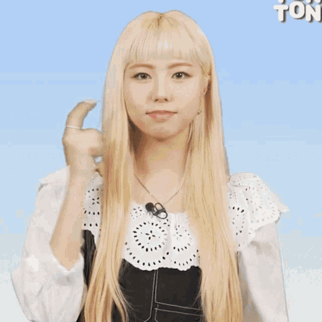 a woman with blonde hair is making a thumbs up sign
